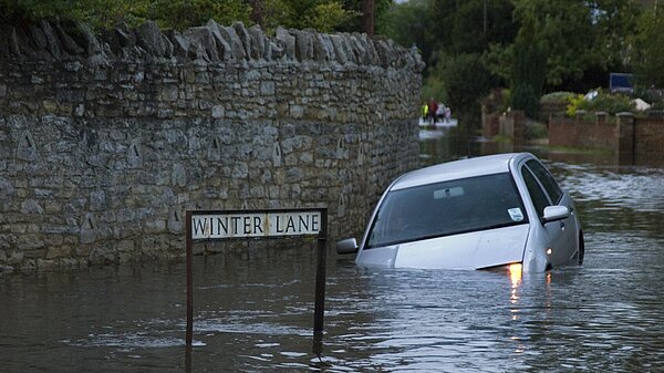 A car covered up to the windows with water after a flood.