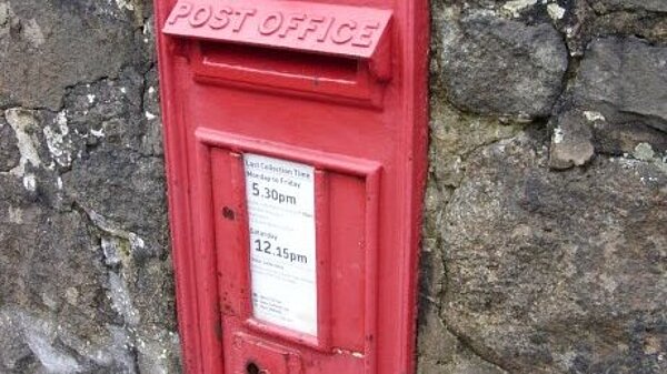 Picture of a British red post box set into a stone wall